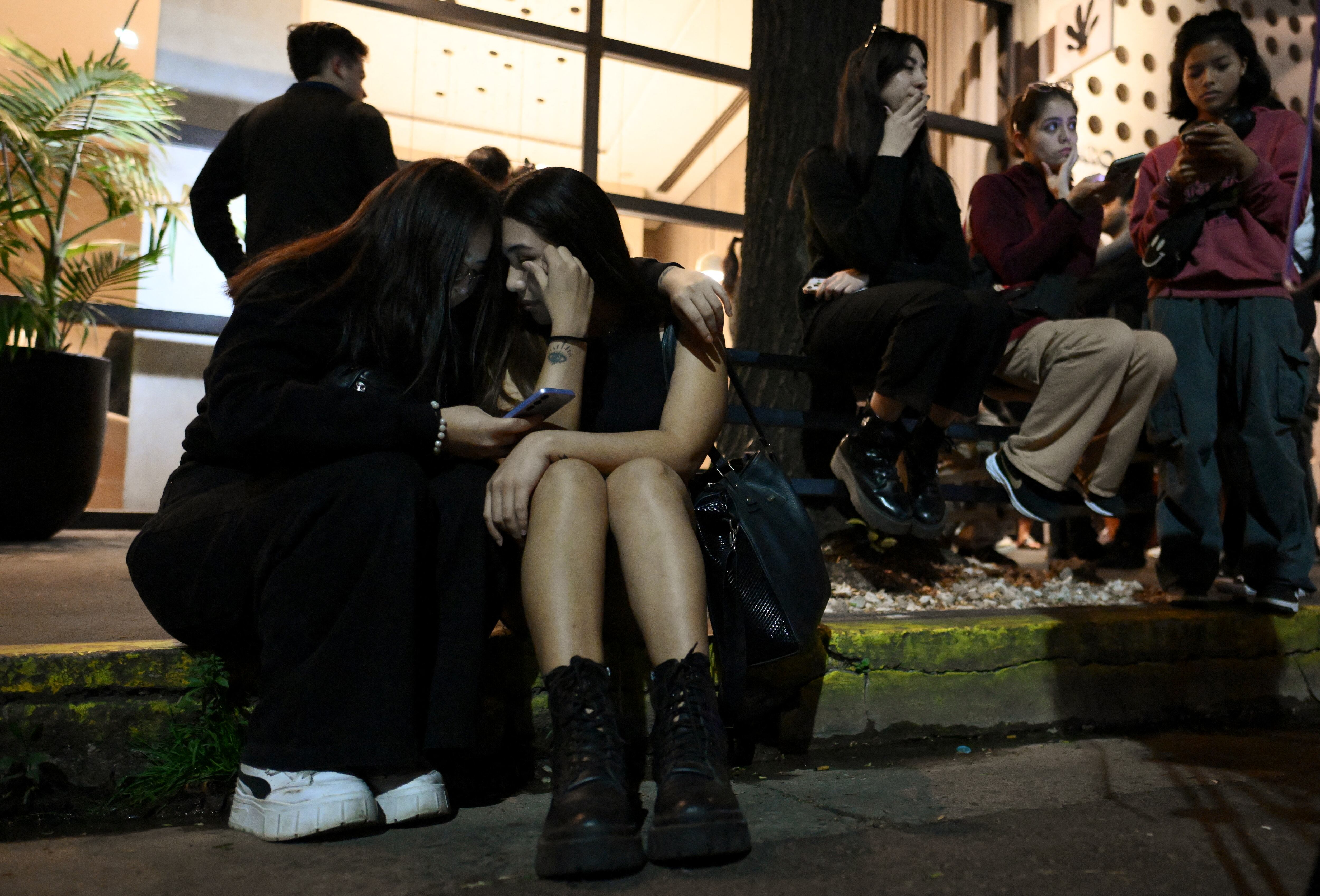 Fans of British singer Liam Payne cry next to the hotel where he died in Buenos Aires on October 16, 2024. British singer Liam Payne, former member of the group One Direction, died Wednesday aged 31 after falling from the third floor of a hotel in Argentina, police in Buenos Aires said. (Photo by Luis ROBAYO / AFP) (Photo by LUIS ROBAYO/AFP via Getty Images)